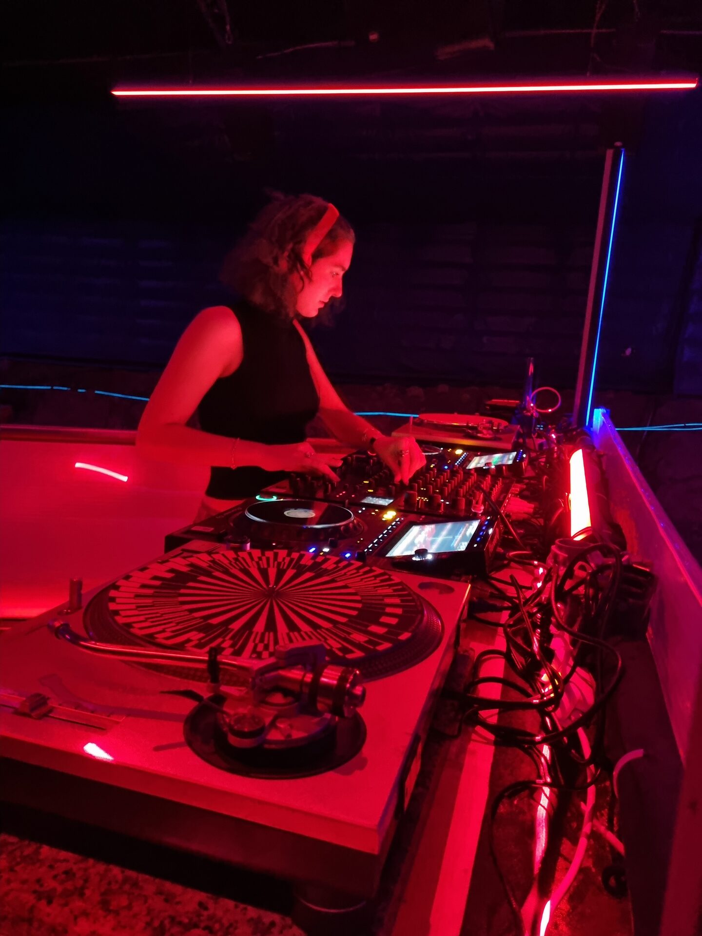 AMNERI behind the decks, bathed in red light